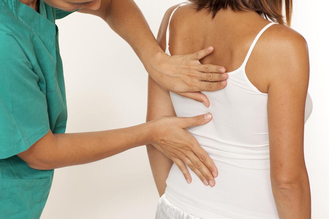 Doctor examines back for shoulder blade pain